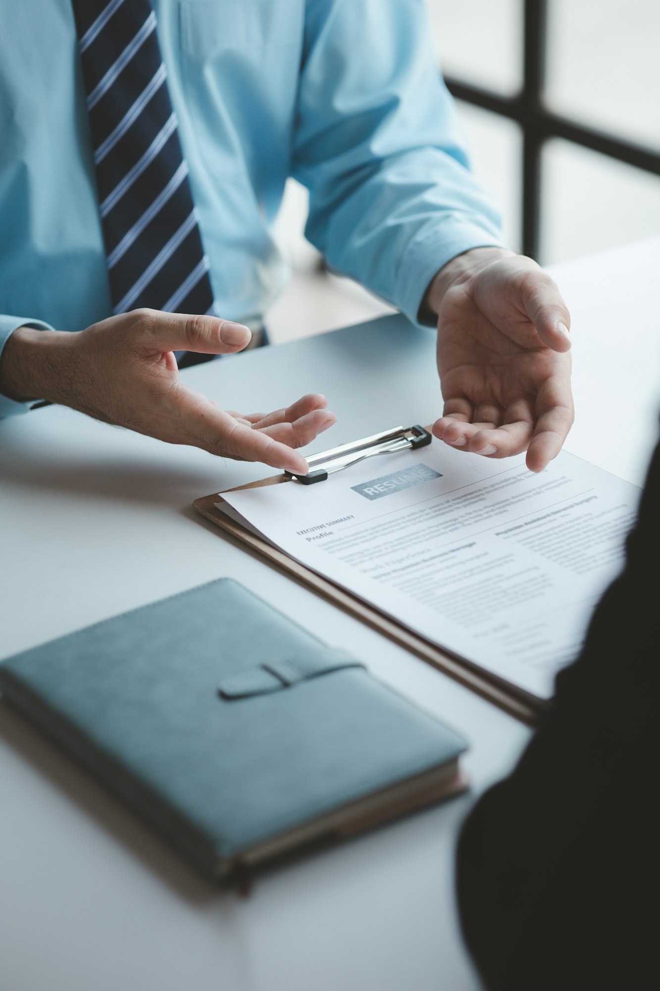 A person attends a job interview with a manager to join a company, he holds a resume and interview w. Jujuju Tienda de productos para piscinas y climatización Alicante