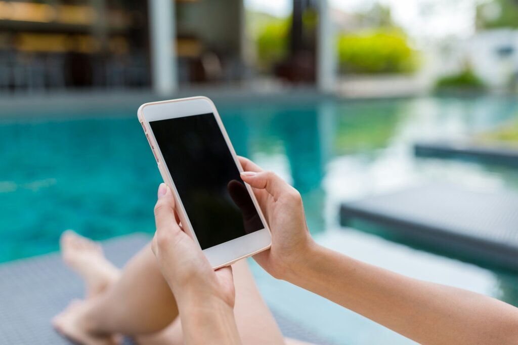 Young Woman using mobile phone in swimming pool