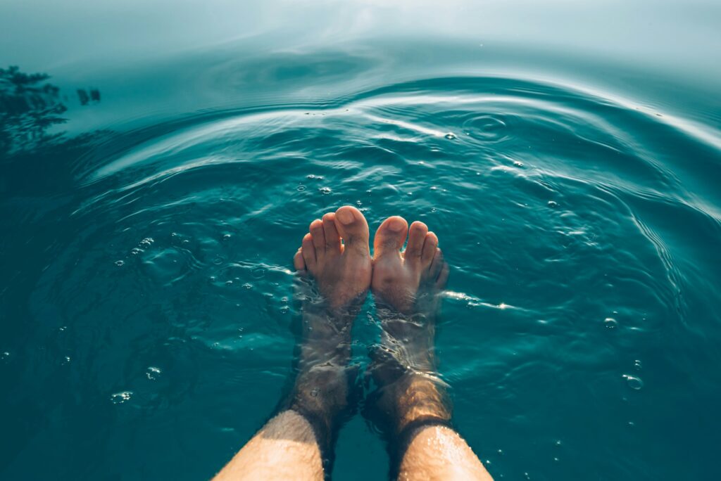 Imagen de pies masculinos disfrutando de una piscina limpia guía de mantenimiento básico de una piscina