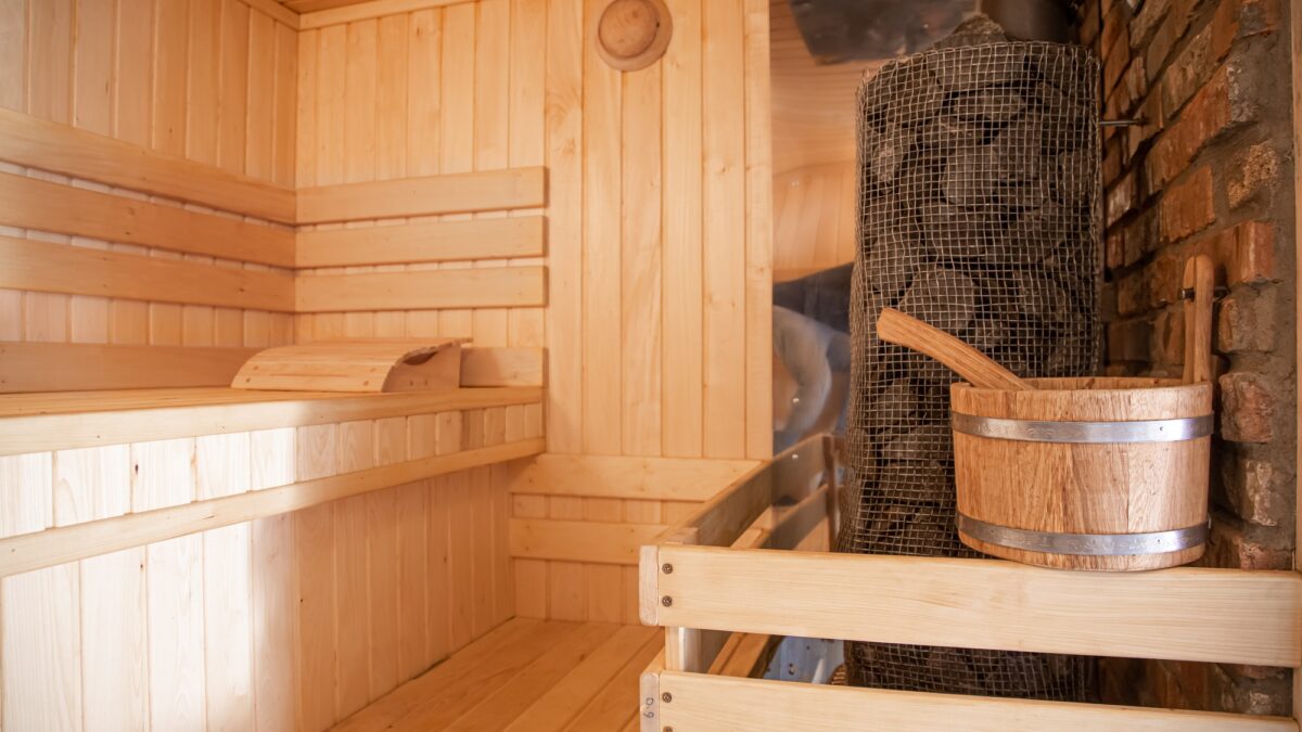 Interior of a wooden Russian sauna with traditional items for use.