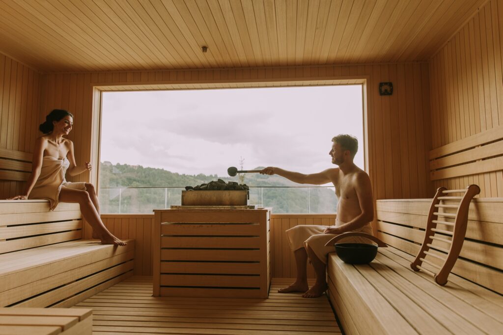 Young couple relaxing in the sauna. Sauna tradicional vs. Infrarroja ¿Cuál elegir?